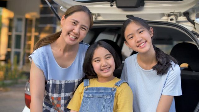 4K Slow motion Happy family sitting on the car front of home