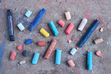 Colored chalks scattered on concrete.