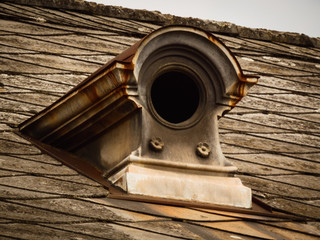 Round medieval roof window on the top of an old historical building. Europe.