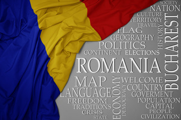 waving colorful national flag of romania on a gray background with important words about country