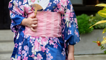 Young girl wearing Japanese kimono standing in the park