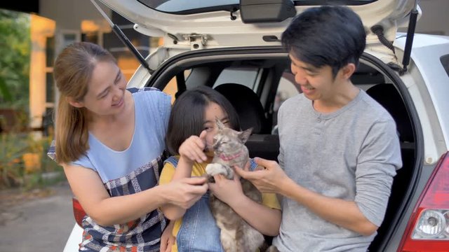 4K Happy family sit on the car and play with cute kitten