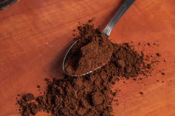 Freshly ground coffee in a slice over a kitchen red table