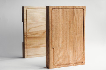 Kitchen and kitchenware. Rustic and rough crockery and utensil. Two rough wooden cutting boards by the white wall . Country style. Wooden handmade tableware. White background.