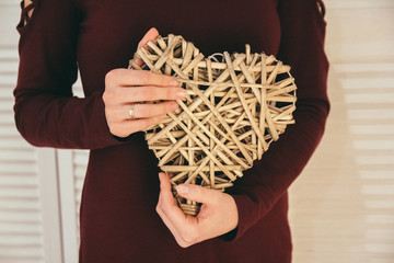 Closeup of heart-shape handmade souvenir show by woman's hands . The symbol of love forever by...