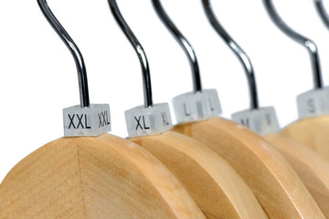 Wooden hangers with sizes tags isolated on white background.