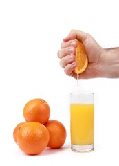 fresh squeezed orange juice with hand squeezing orange  - glass with fresh squeezed orange juice and oranges isolated on white