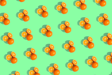 Oranges on a bright colored green background. Repeating pattern, preparation for wallpaper citrus mood.