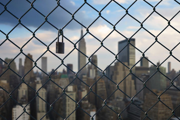 New York city behind steel mesh wire fence. Concept