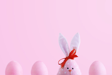 Handmade rabbit among Easter eggs, concept of celebration and fun.