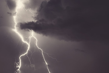Fototapeta na wymiar Lightning strike on the night cloudy sky