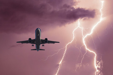 Passenger airplane landing in the stormy weather on the backdrop lightning