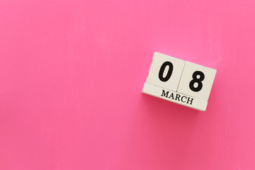wooden March 8 calendarover pink wooden background. View from above, flat lay