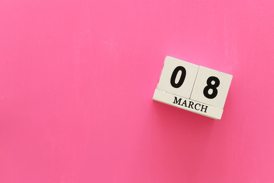 wooden March 8 calendarover pink wooden background. View from above, flat lay
