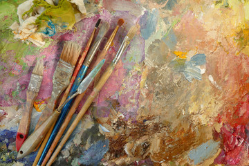old art brushes on a palette with paints. top view. copy space