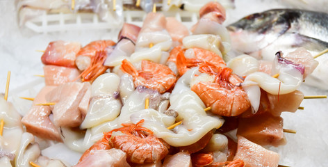 fresh peeled seafood shrimp and squid with pieces of salmon in the ice, Italian market, Italian cuisine. selective focus
