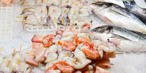 fresh peeled seafood shrimp and squid with pieces of salmon in the ice, Italian market, Italian cuisine. selective focus