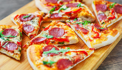 Pepperoni Pizza with Mozzarella cheese, salami, Tomatoes, pepper, Spices and Fresh arugula. Italian pizza on wooden table background