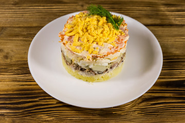 Traditional russian salad Mimosa on wooden table