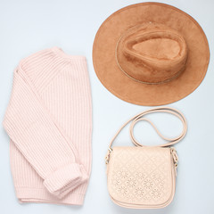 Fashionable knitted sweater, felt hat, leather bag, leather bag on a gray background.Women's clothing and accessories. Top view..