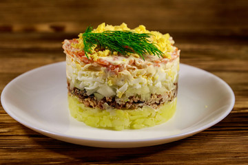 Traditional russian salad Mimosa on wooden table
