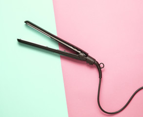 Hair straightener on pastel background. Top view. Minimalism.