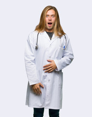 Fototapeta premium Lekarz mężczyzna z zaskoczeniem i zszokowany wyraz twarzy na na białym tle