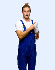 Workman surprised and pointing side on isolated background