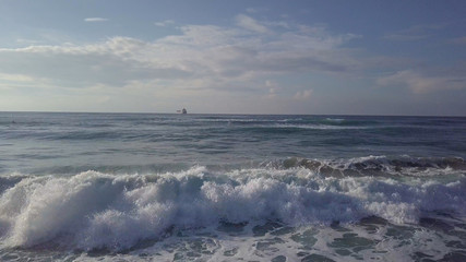 Fototapeta premium Aerial sliding trough stormy waves to sea tanker at horizon