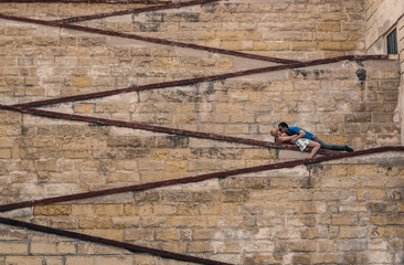 Man kissing woman laying on the city walls