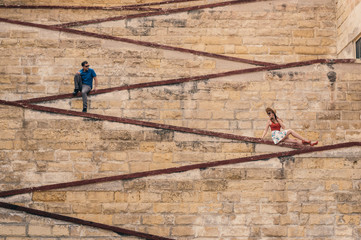 Naklejka na ściany i meble Man and woman sitting on the city walls
