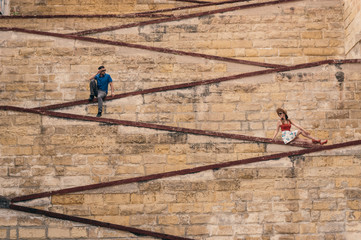 Man and woman sitting on the city walls
