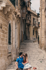 Fototapeta na wymiar Man and woman walking and kissing on the stairs on the street