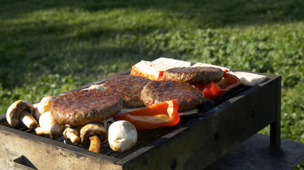 Assorty on grill at summer barbecue, cheese, vegetables, mushrooms and cuttlets