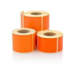 Orange label roll isolated on white background with shadow reflection. Color reel of labels for...