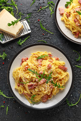 Classic Carbonara pasta, spaghetti with pancetta, bacon, egg, parmesan cheese and green arugula.