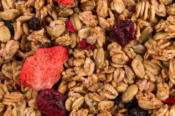 Muesli oat cereals close up background with dry fruits