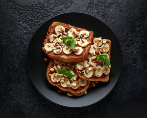 French cinnamon toast with banana, nuts and hazelnut, honey.