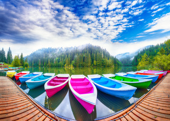 Boats on majestic mountain lake Lacul Rosu or Red Lake or Killer Lake