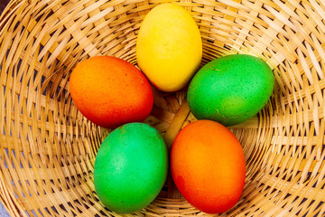 Five colorful easter eggs in a straw basket isolated 