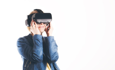 A young woman is wearing virtual reality glasses and reaching for something with his hands