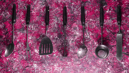 Retro metal cooking tool set on red concrete background