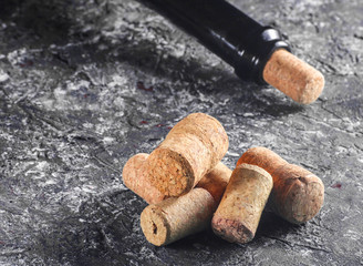 Corks for bottle of wine and wine bottle on gray concrete background.