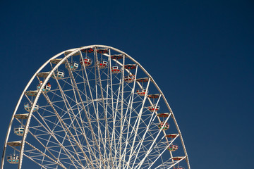 Construction of white Blumenrad ferris wheel in Prater amusement park in Vienna Austria on blue sky background