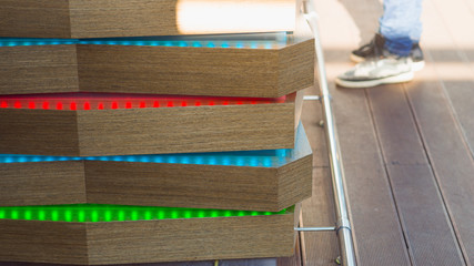 green, blue and red neon lines in wooden wall background.