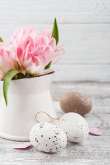 Fresh flowers in jug and Easter eggs