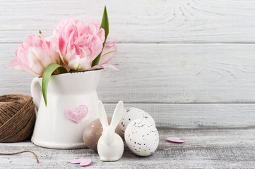 Fresh flowers in jug and Easter eggs