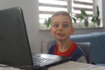 mały chłopak jest zadowolony używa laptopa 