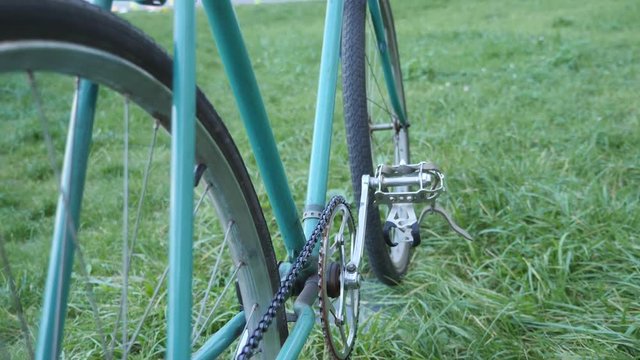 Close up view of a green track fixed retro bicycle on the green grass