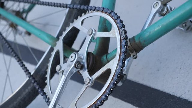 Close up view of a green track fixed retro bicycle on a velodrome 